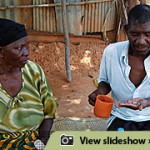 A man in Tanzania sorts his medication while his mother looks on.